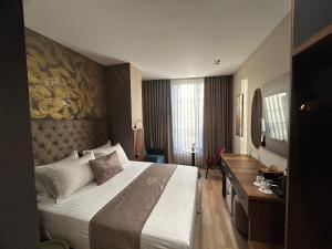 a hotel room with a large bed and a desk at Hotel Shopi Residence in Elbasan