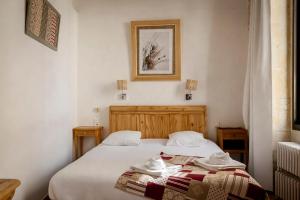 a bedroom with two beds and a picture on the wall at Hôtel La Muette in Arles +22 photos