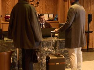 two men standing in front of a desk with a computer at Swissôtel Resort Kolasin in Kolašin +165 photos