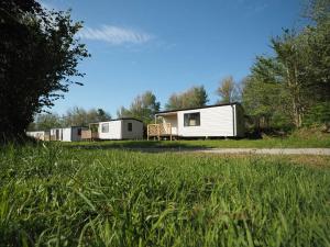 a row of mobile homes parked in a field at Le Village des Pingouins à Porspoder in Porspoder