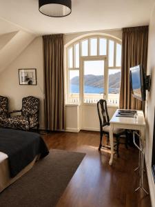 a bedroom with a bed and a desk and a television at Grand Hôtel Mölle in Mölle