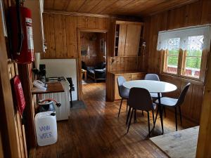 a kitchen with a table and chairs in a room at Simple and cozy forest cabin in Eidsstryken