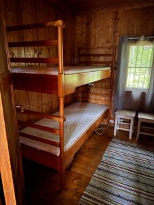 a room with two bunk beds in a cabin at Simple and cozy forest cabin in Eidsstryken
