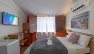 a small bedroom with a bed and a window at Pousada Porto Amazônia in Porto De Galinhas