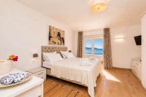 a bedroom with a bed and a view of the ocean at Villa Bilic in Rogoznica
