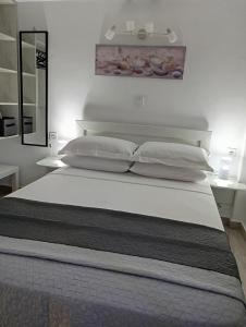 a bed with white sheets and pillows in a bedroom at Calma Kourouta Apartments in Kourouta