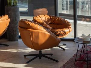 a brown leather chair sitting in a room at Mercure Prishtina City in Prishtinë