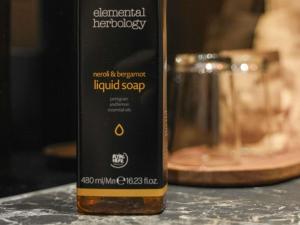 a bottle of liquid soap sitting next to a glass at Mercure Prishtina City in Prishtinë +66 photos
