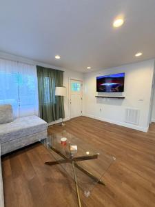 a living room with a couch and a tv on a wall at Two Trees Retreat in Salt Lake City