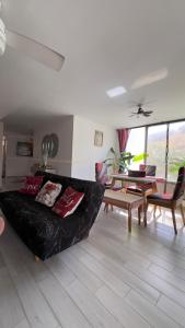 a living room with a black couch and a table at Rodadero Oasis in Santa Marta