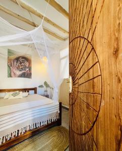 a bedroom with a bed and a wooden wall at Jambiani Kite Lodge in Jambiani +32 photos