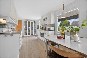 a kitchen with white counters and a table with chairs at Family Holiday Home with Jacuzzi and Fireplace in Hejls