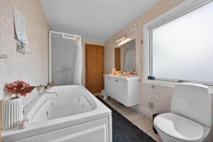 a bathroom with a tub and a toilet and a sink at Family Holiday Home with Jacuzzi and Fireplace in Hejls +21 photos
