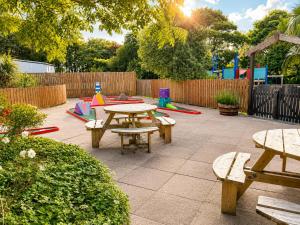 a patio with picnic tables and a playground at 47 Trevithick Court in Hayle