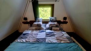 a bed in a room with a window at Ariel 2 Vendégház in Pilismarót