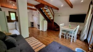 a living room with a table and chairs and a tv at Ariel 2 Vendégház in Pilismarót