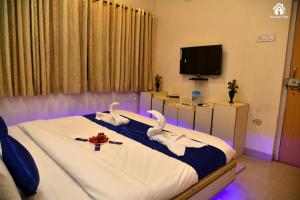 a bedroom with swans on a bed with a tv at CHOCOLATE VILLA Mahabaleshwar in Mahabaleshwar
