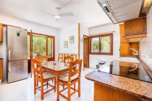 a kitchen and dining room with a table and chairs at Can Jordi in Cala Llombards