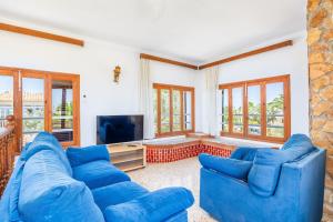 a living room with blue couches and a tv at Can Jordi in Cala Llombards
