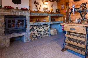 a living room with a stone fireplace and a stove at Chata Borovec in Veľké Borové