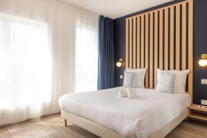 a bedroom with a large white bed with blue walls at Ibis Styles Paris Pont d'Ivry in Ivry-sur-Seine