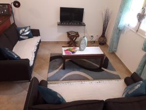 a living room with a couch and a coffee table at Le camphrier in Salazie
