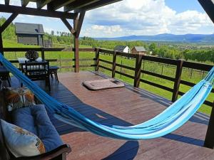 a hammock on a deck with a view at Domek w górach Łubinowa 6 in Międzylesie