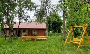 two wooden benches in a yard with a house at Malowany Domek in Przymiłowice