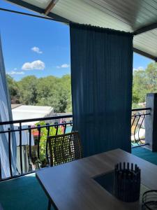 a balcony with a table and chairs and a large window at Apartmani Žak in Pridraga