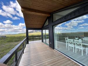 a wooden deck with a table and chairs on it at Brúarárbyggð B1 in Blaskogabyggo