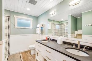 ein Badezimmer mit zwei Waschbecken, einer Toilette und einem Spiegel in der Unterkunft Point Perfect in Port Madison + 37 Fotos