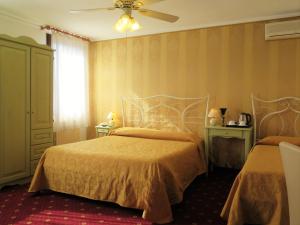 a bedroom with two beds and a ceiling fan at Al Soffiador in Murano