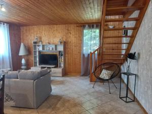 a living room with a couch and a television at Isa's Little Cottage in Saint-Bonnet-de-Chirac