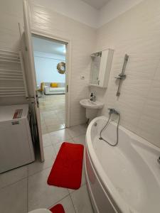 a bathroom with a tub and a toilet and a sink at RC RelaxApart 314 in Dudu