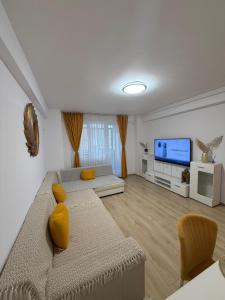 a living room with a couch and a flat screen tv at RC RelaxApart 314 in Dudu