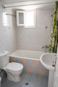 a bathroom with a toilet and a tub and a sink at Crystal Kimolos in Kimolos