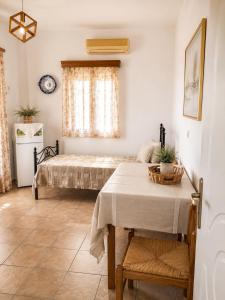 a bedroom with a bed and a table and a window at Crystal Kimolos in Kimolos