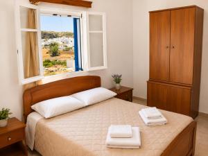 a bedroom with a bed with two towels on it at Crystal Kimolos in Kimolos