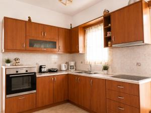 a kitchen with wooden cabinets and a stove top oven at Crystal Kimolos in Kimolos