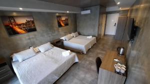 a hotel room with two beds and a couch at El Norte Hotel in Río Segundo