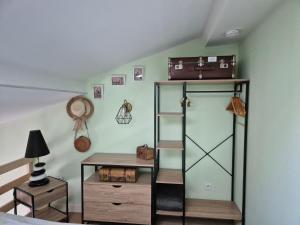 a room with a shelf with a suitcase on the wall at Gîte de la Lorada in Nouaillé-Maupertuis