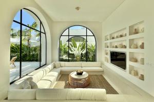 a living room with a white couch and a large window at Dolce x The Young Villas in Uluwatu