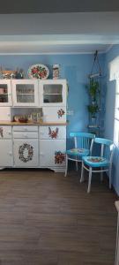 a blue room with white furniture and blue walls at Malowany Domek in Przymiłowice