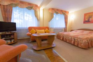 a bedroom with a bed and a chair and a tv at Smolenskhotel in Smolensk