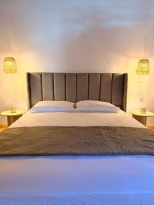 a bedroom with a large bed with two tables at Κουρείον Kourion in Agios Vlasios