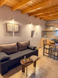 a living room with a couch and a table at Κουρείον Kourion in Agios Vlasios