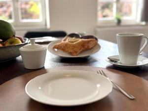 a table with plates of food and cups of coffee at Bad Oeynhausen - City, Küche, Netflix, Wifi, zentral, StudioApartment in Bad Oeynhausen