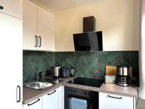 a kitchen with a sink and a microwave at Bad Oeynhausen - City, Küche, Netflix, Wifi, zentral, StudioApartment in Bad Oeynhausen