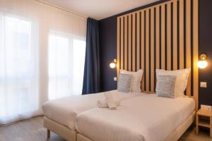 a bedroom with a large white bed with pillows at Ibis Styles Paris Pont d'Ivry in Ivry-sur-Seine