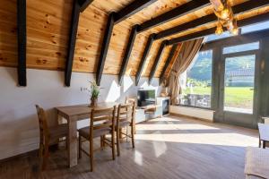 a dining room with wooden ceilings and a table and chairs at Ali-pašin Konak in Gusinje